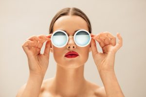 junge Frau mit Brille ist ohne Falten nach einer Botox Behandlung