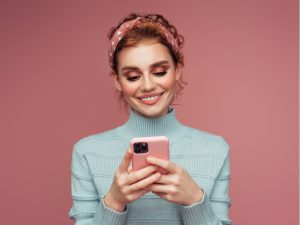 Junge Frau vereinbart einen Termin online mit dem Handy